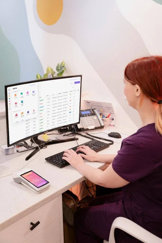 Medical clinic front desk with patient payment terminal and practice software