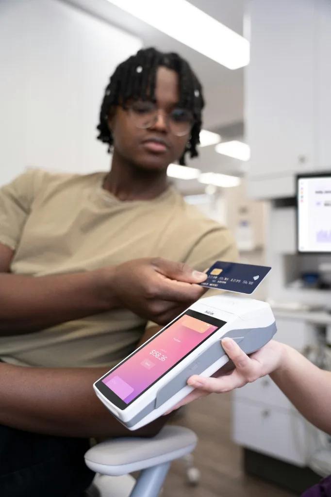 Veterinary staff member with dog and handheld payment terminal