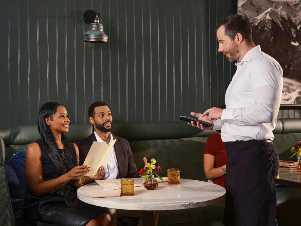 Server taking an order with handheld POS at a full-service restaurant